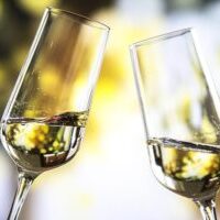 two-clear-wine-glasses-with-yellow-liquid-300x200